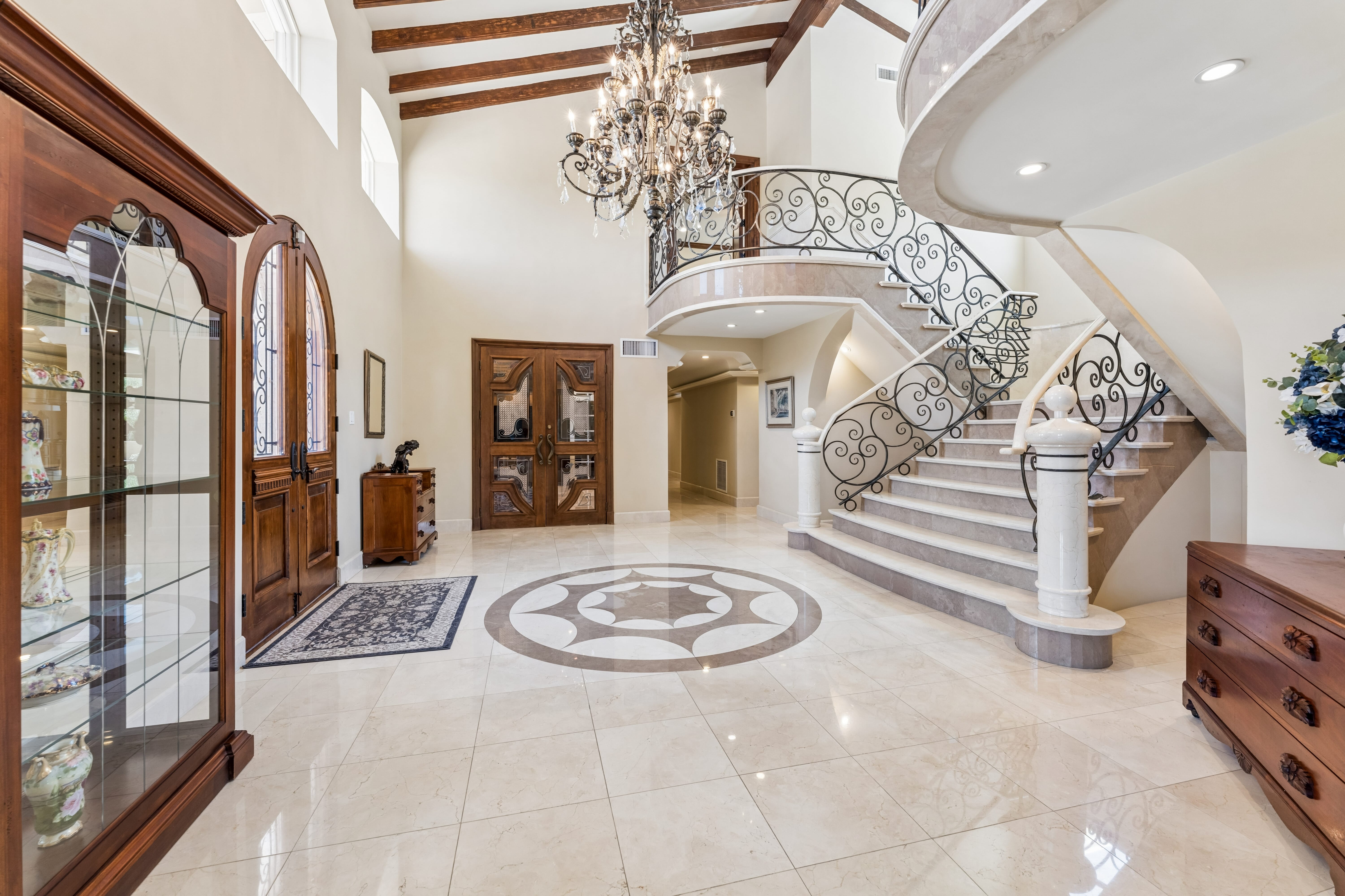 Grand foyer with chandelier and iron staircase