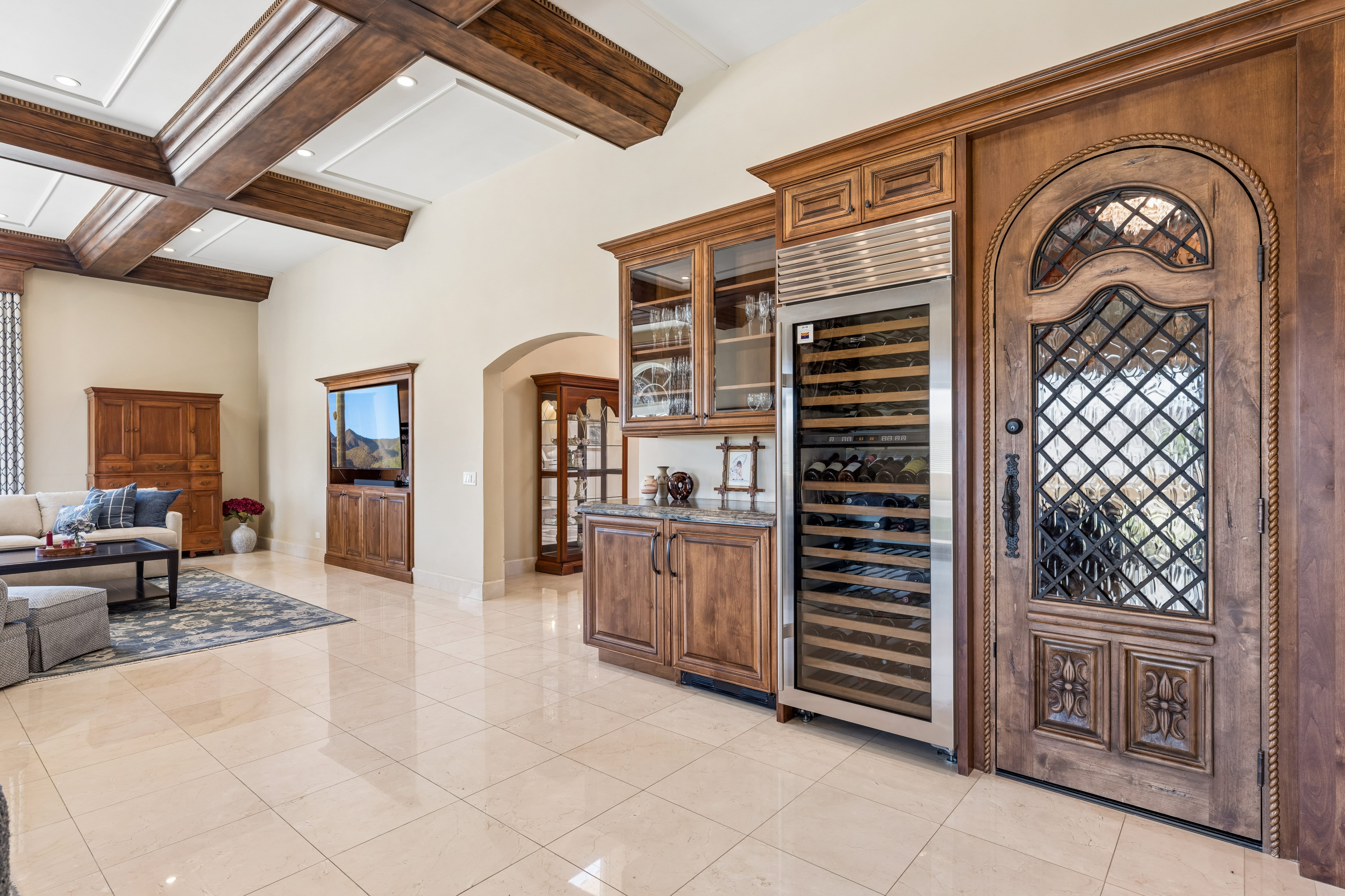 Butler's bar with wine refrigerator and coffered ceiling