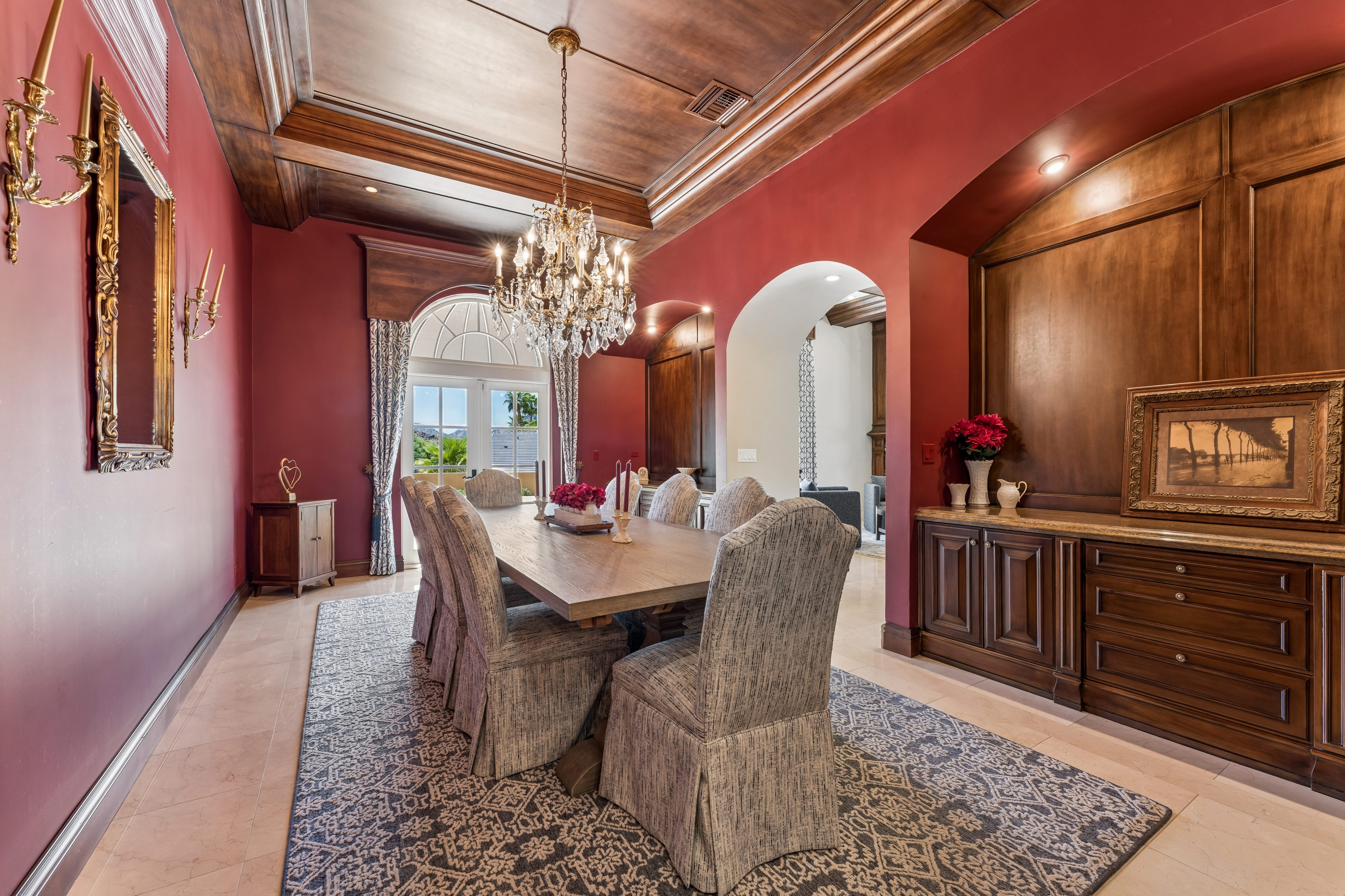 Dining room with walnut tray ceiling and arched window view
