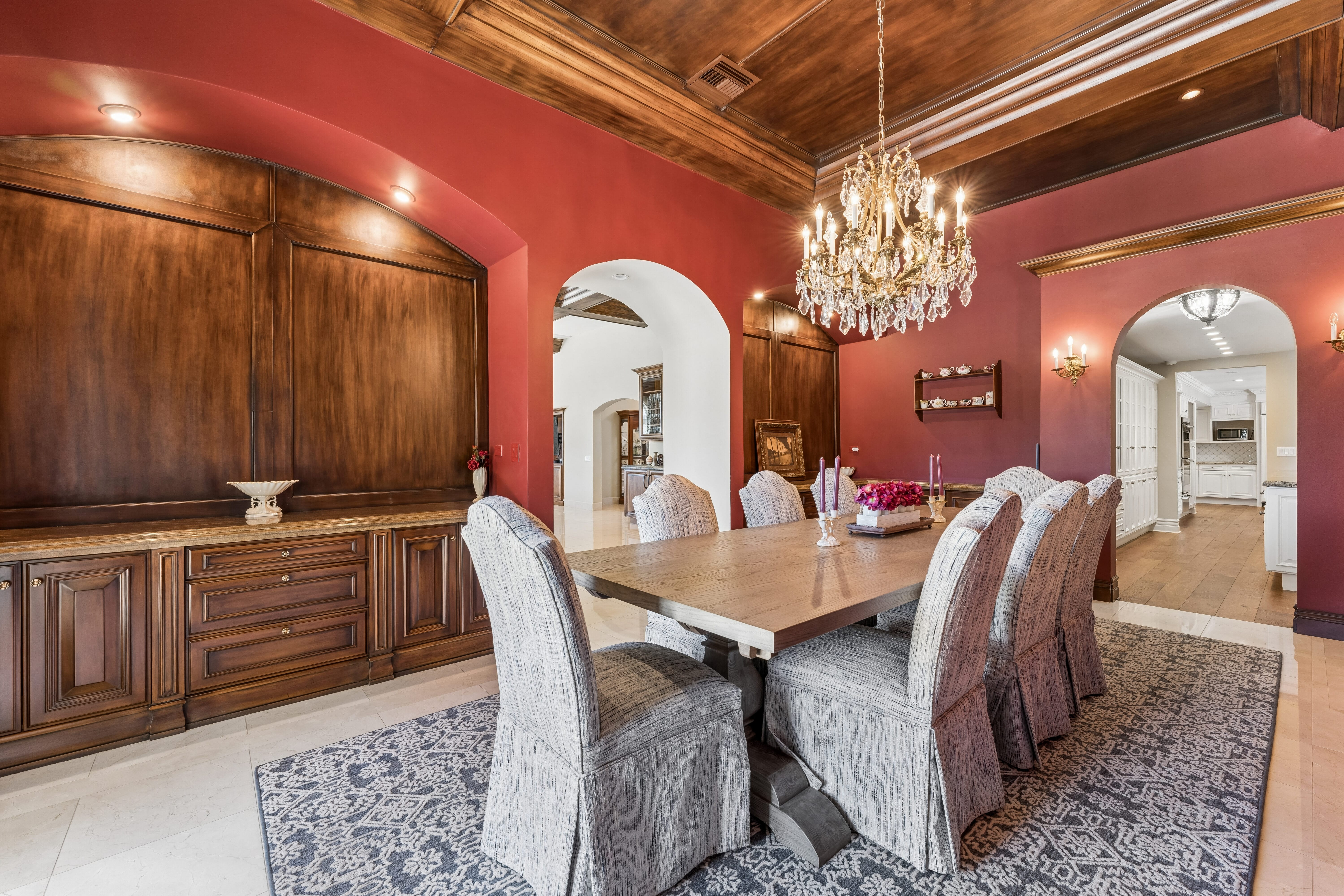 Formal dining room with crimson walls and crystal chandelier