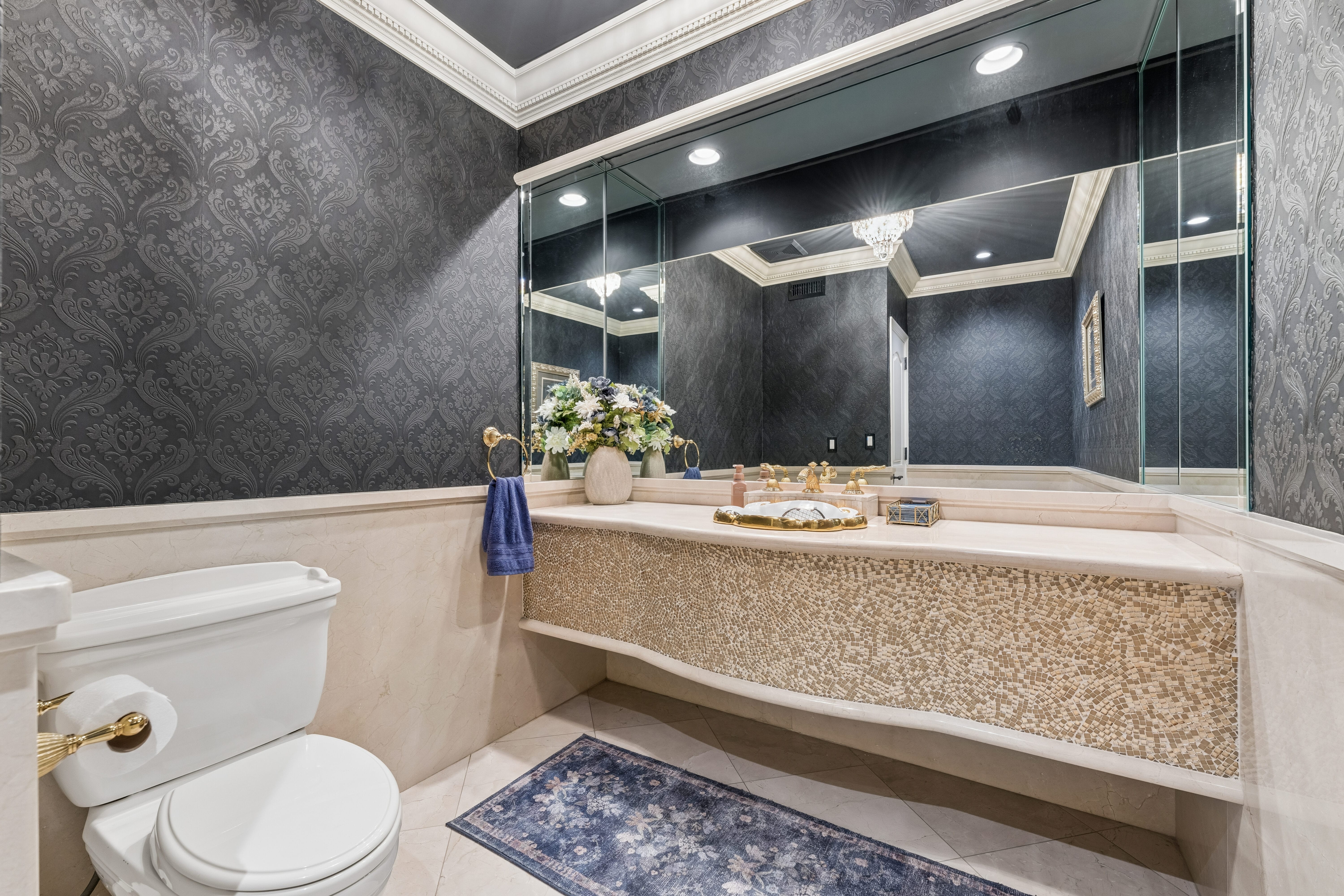 Powder room with damask wallpaper and gold mosaic vanity