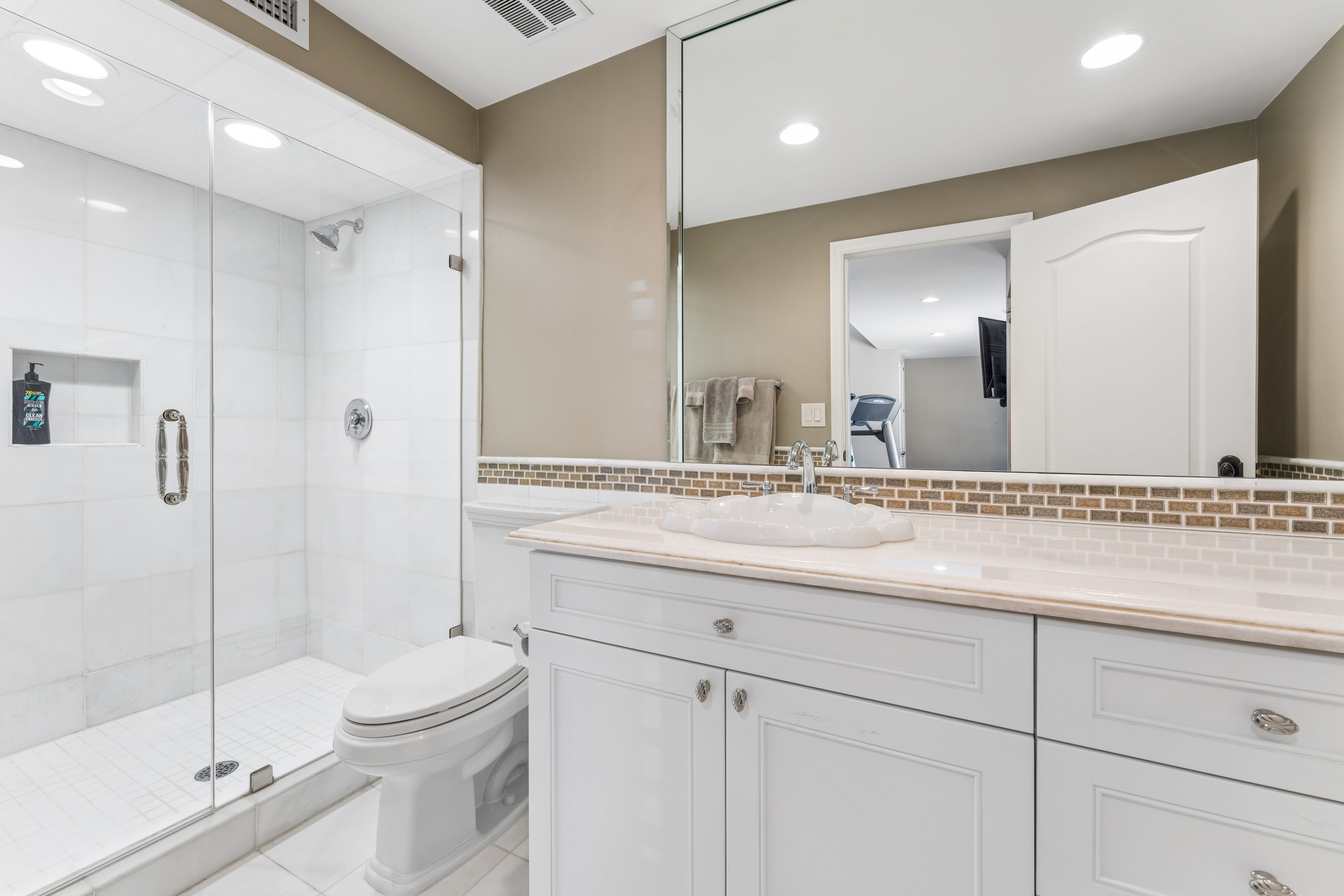 Guest ensuite bath with glass shower and marble vanity