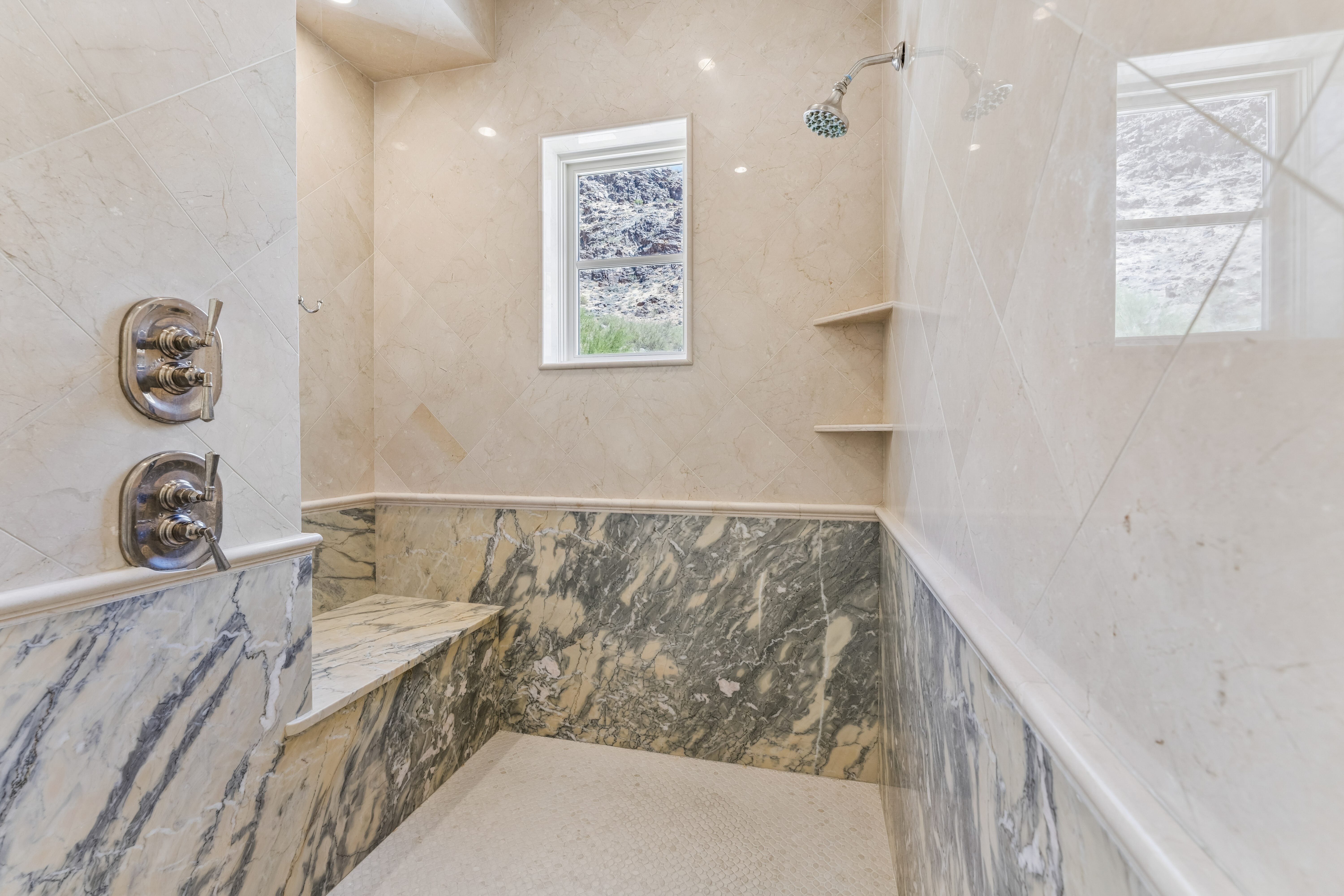 Primary shower interior with marble bench and canyon window