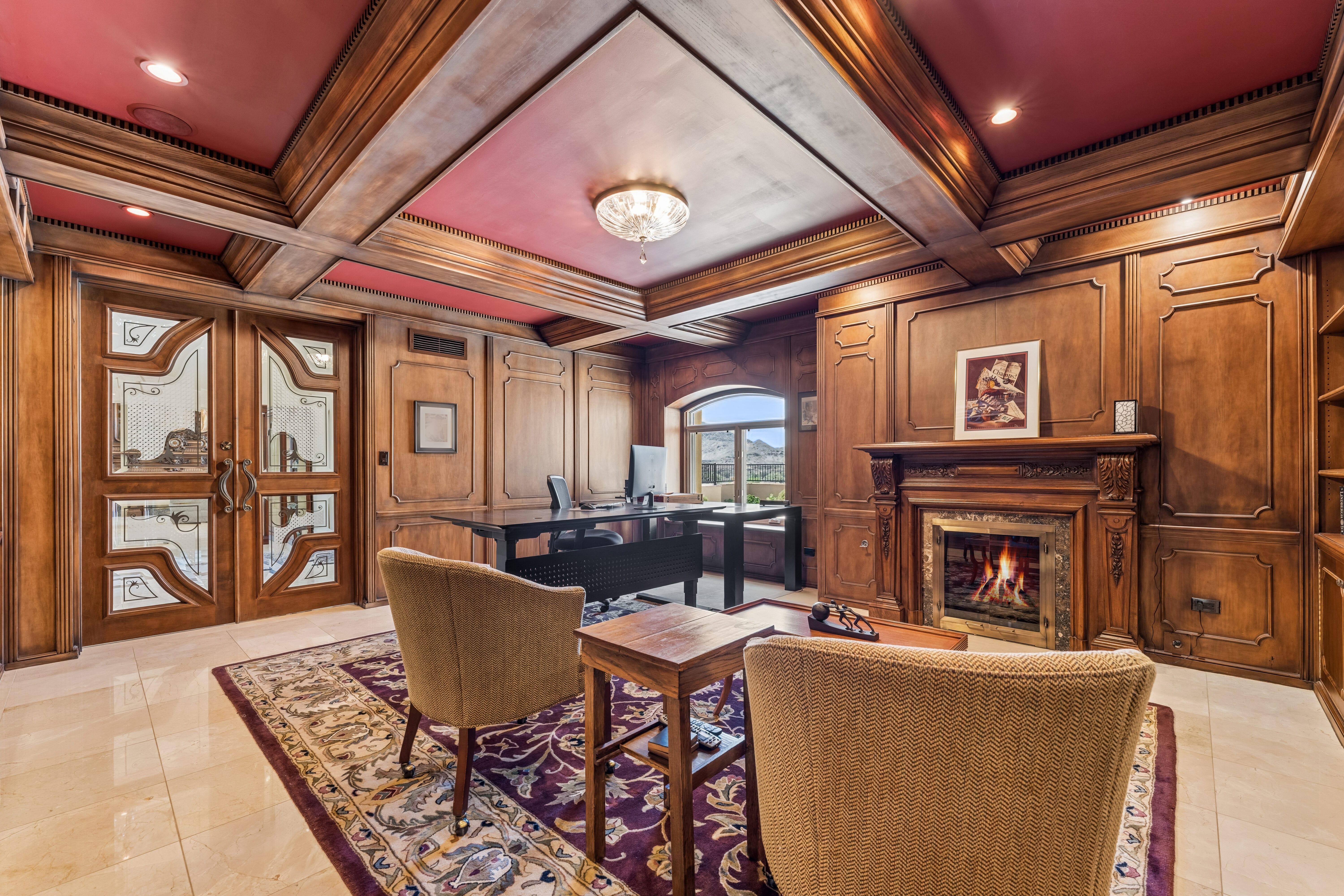 Library office with carved fireplace and mountain view window