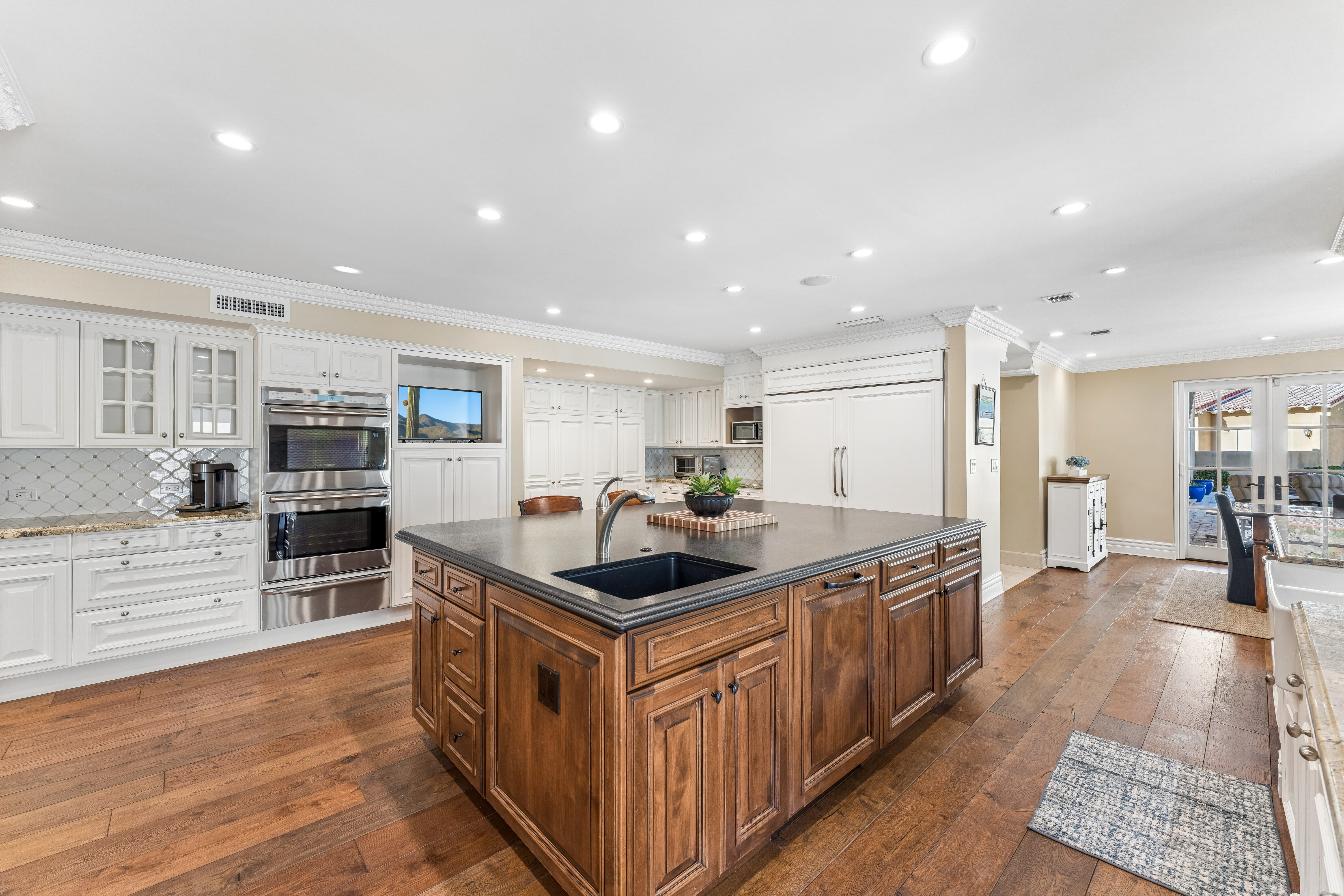 Breakfast nook with brick fireplace and French doors to pool