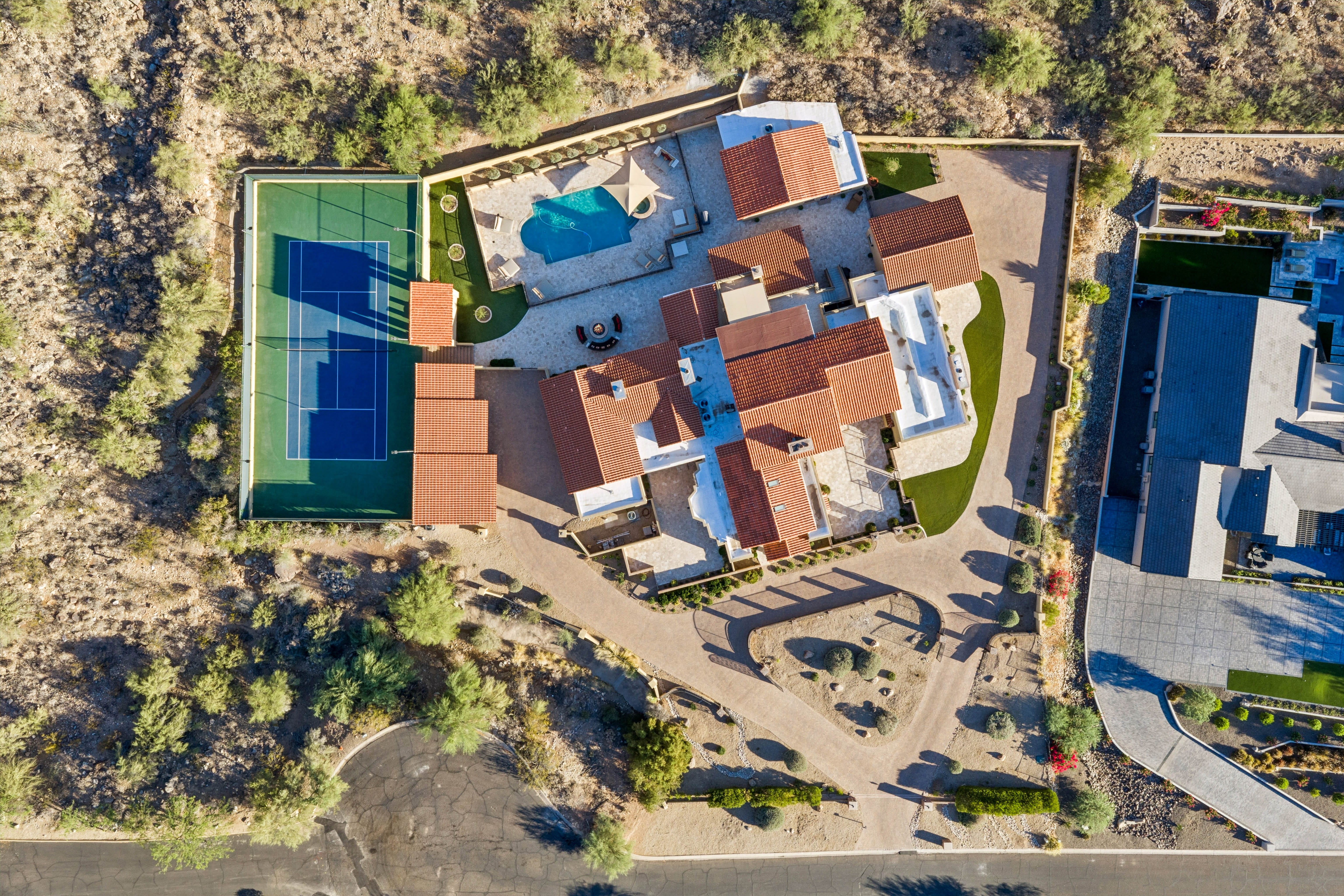 Mountain-scale aerial showing luxury estate in canyon