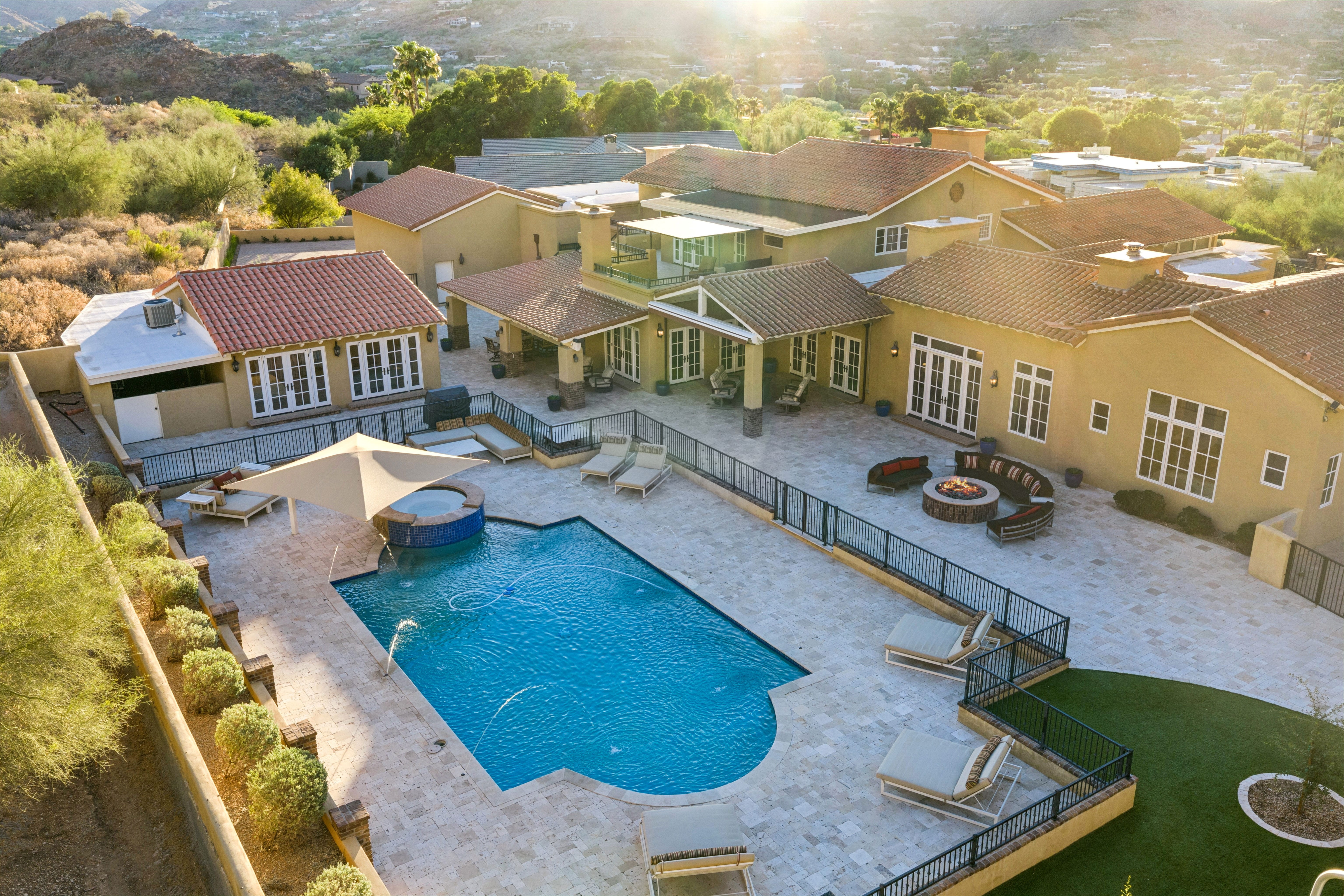 Golden hour aerial of pool and full luxury estate