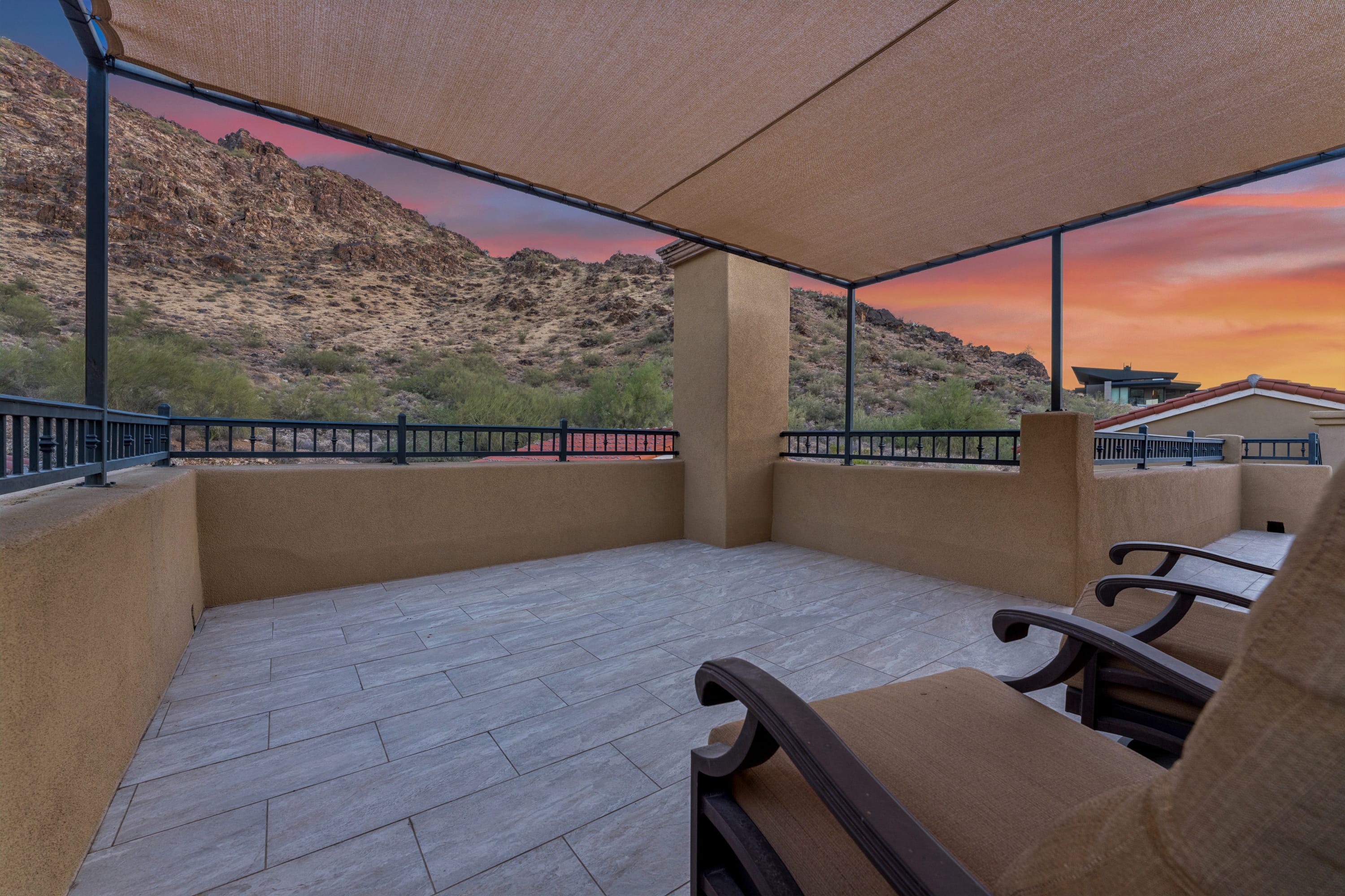 Shaded balcony lounge at sunset with crimson sky